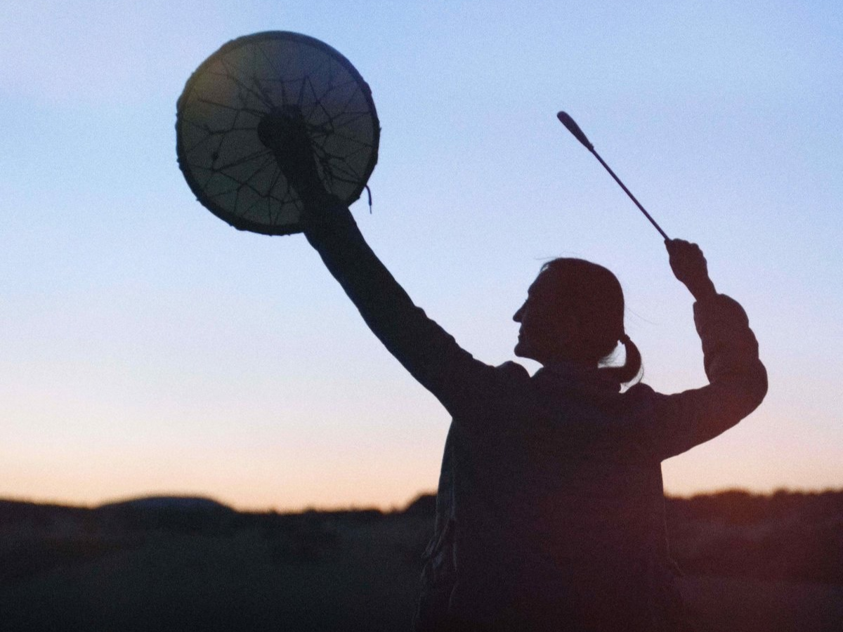 A person holds a hand drum and beater at sunset in the 2026 documentary Little Singer, a film exploring Diné cultural continuity.